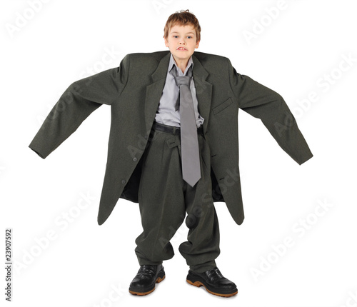 little boy in big grey man's suit and boots nads at sides