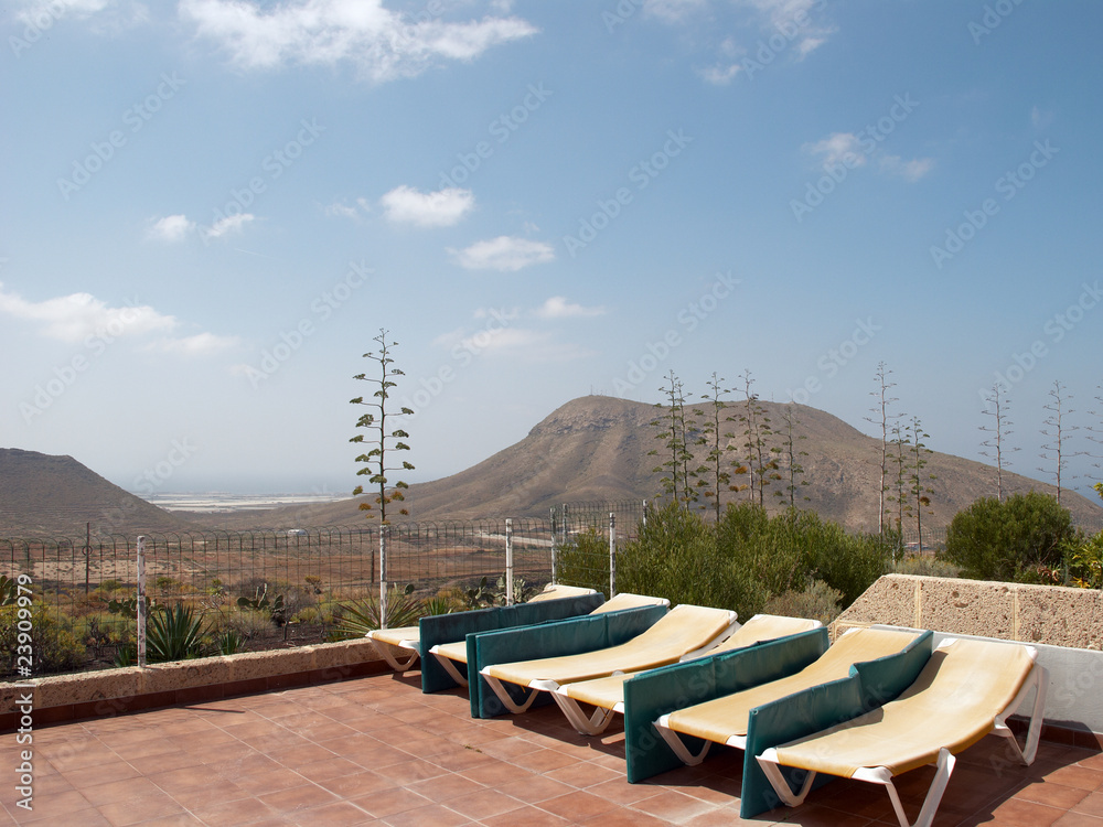 Fototapeta premium Beach chairs against blue sky and mountains