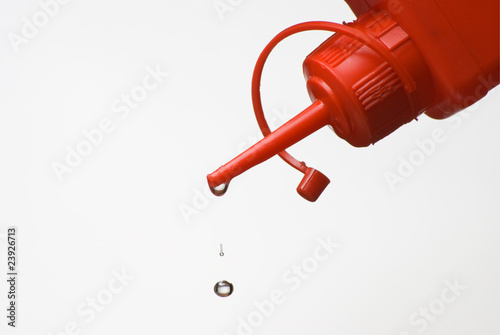 Dripping plastic oil can over white