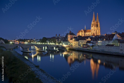 Altstadt Regensburg, beleuchteter Dom und Steinerne Brücke zur blauen Stunde mit Reflektion in Donau