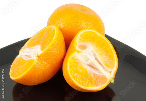 oranges on plate on white background