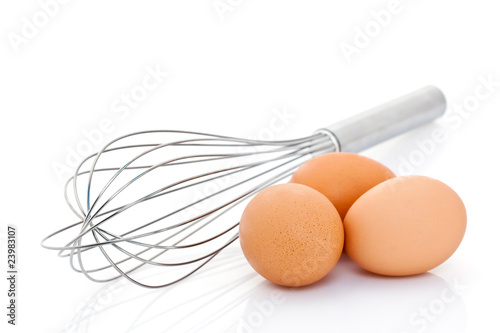 Fouet et oeufs sur fond blanc
