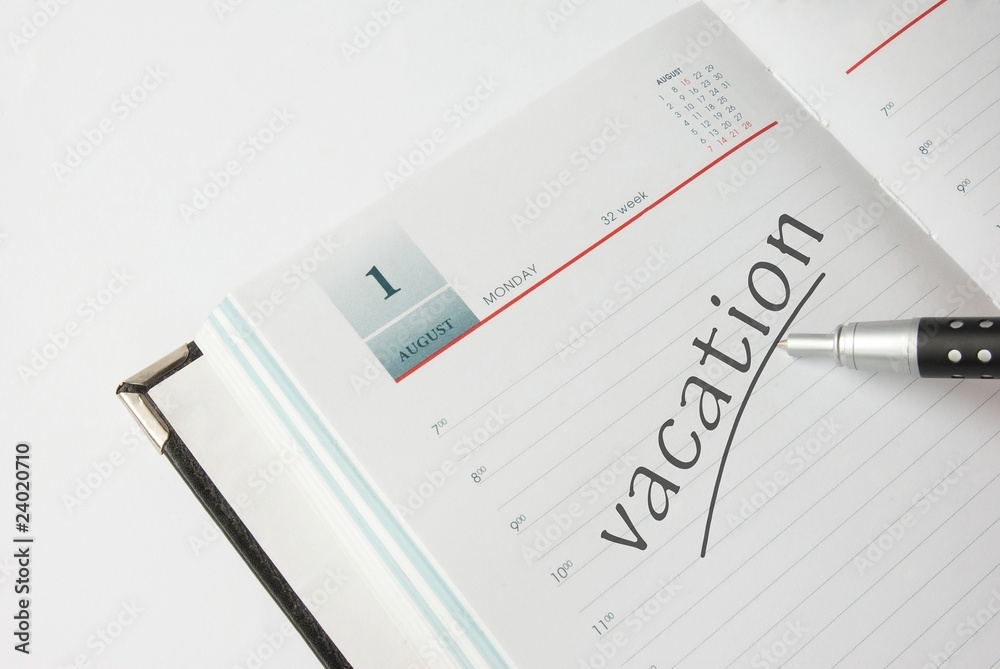 Appointment book with pen and vacation text Appointment book with pen and vacation text