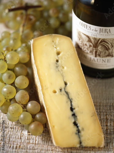 morceau de morbier, vin du jura et grappe de raisin 