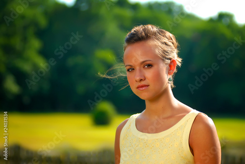 A pretty girl outdoors in a yellow dress.