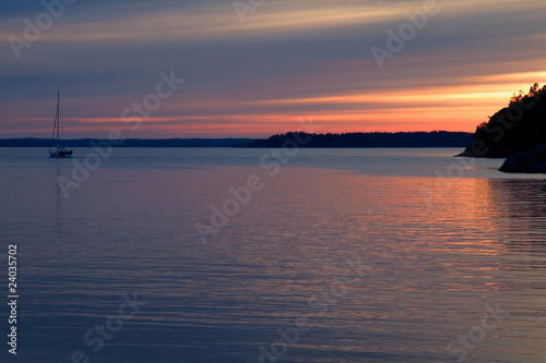 Sailboat leaving at sunset.