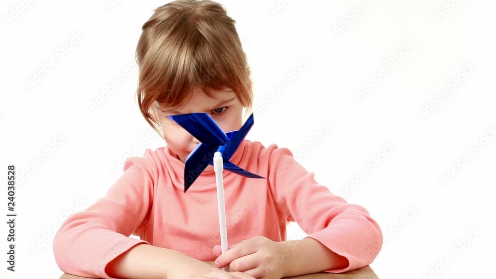 girl blows strongly on propeller, windmill and it turns quickly girl blows strongly on propeller, windmill and it turns quickly