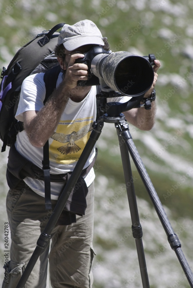 Nature photographer with heavy telephoto lens