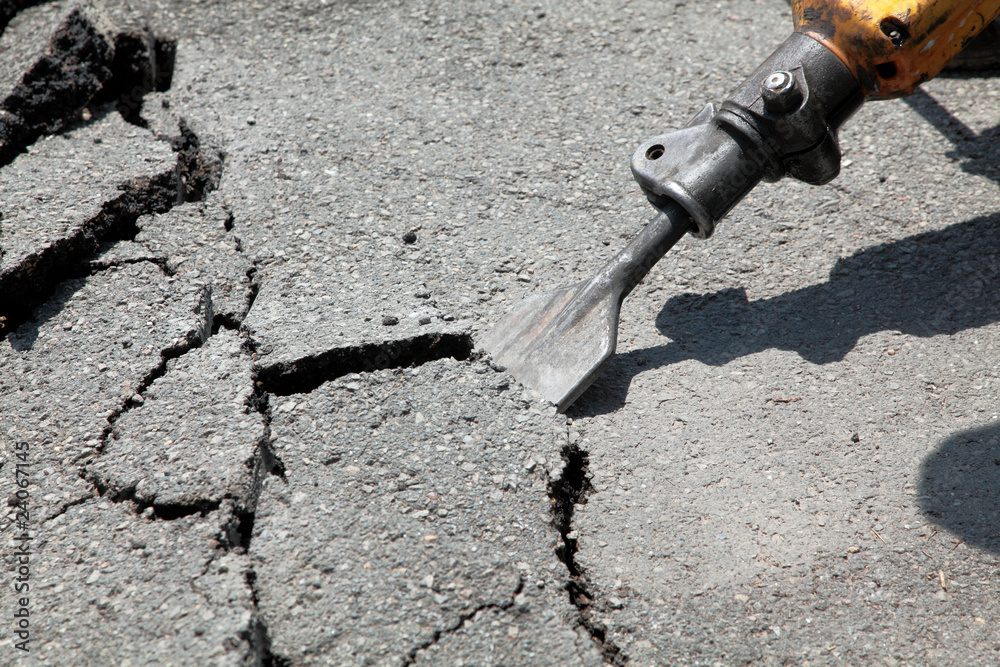 Breaking asphalt with pneumatic hammer - jackhammer