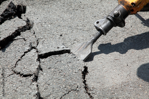 Breaking asphalt with pneumatic hammer - jackhammer photo