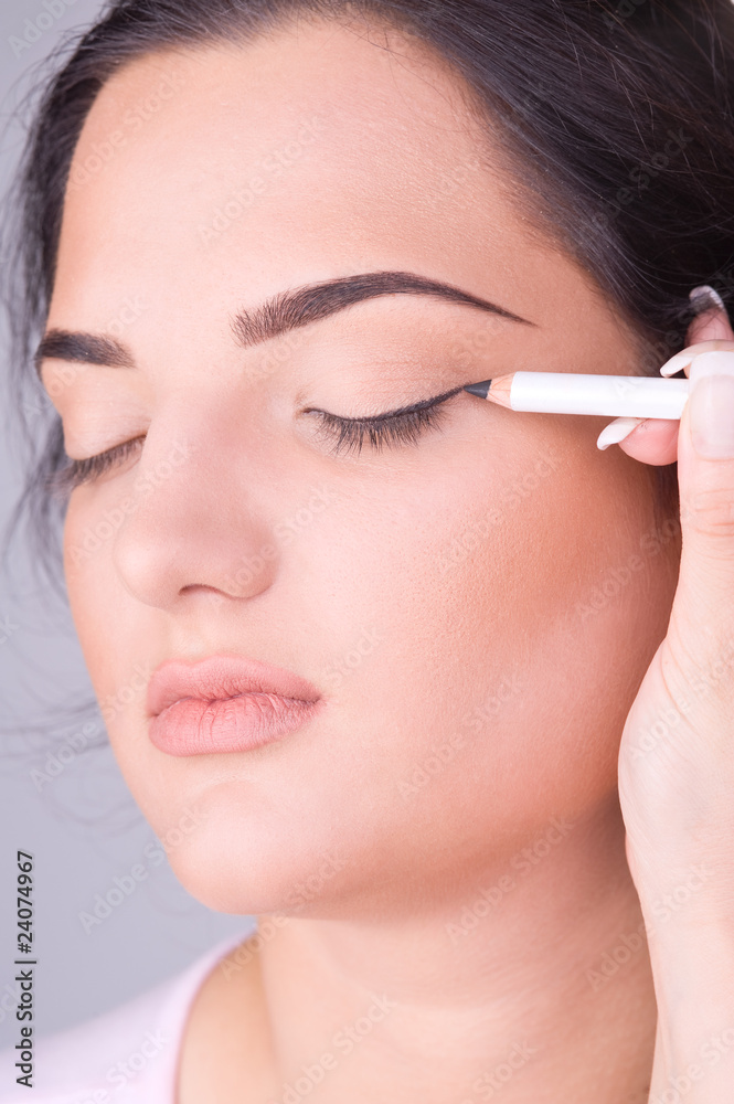 Close up look of a young female doing make up Close up look of a young female doing make up