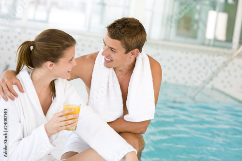 Young happy couple relax at swimming pool