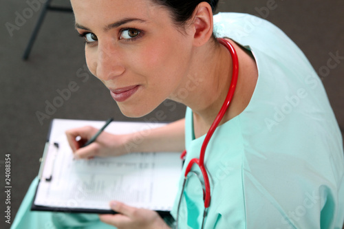 Infirmière remplissant dossier médical photo