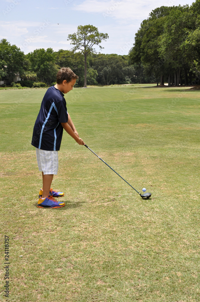 Fototapeta premium young boy driving a golf ball