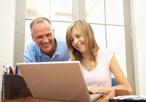 Father And Teenage Daughter Using Laptop At Home © Monkey Business