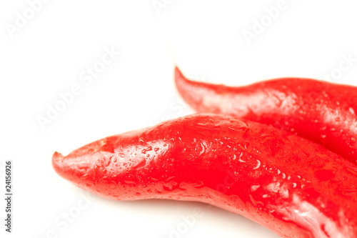 two fresh red hot peppers on white with water drops