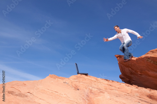 Man with laptop jumping