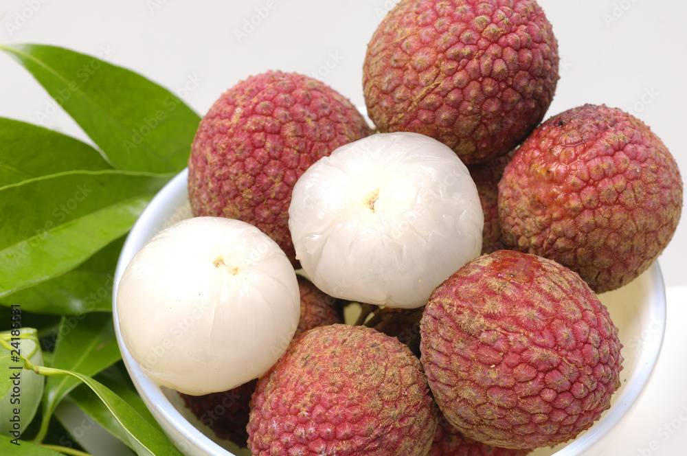 Bowl of Lychees and two peeled with leaf Bowl of Lychees and two peeled with leaf