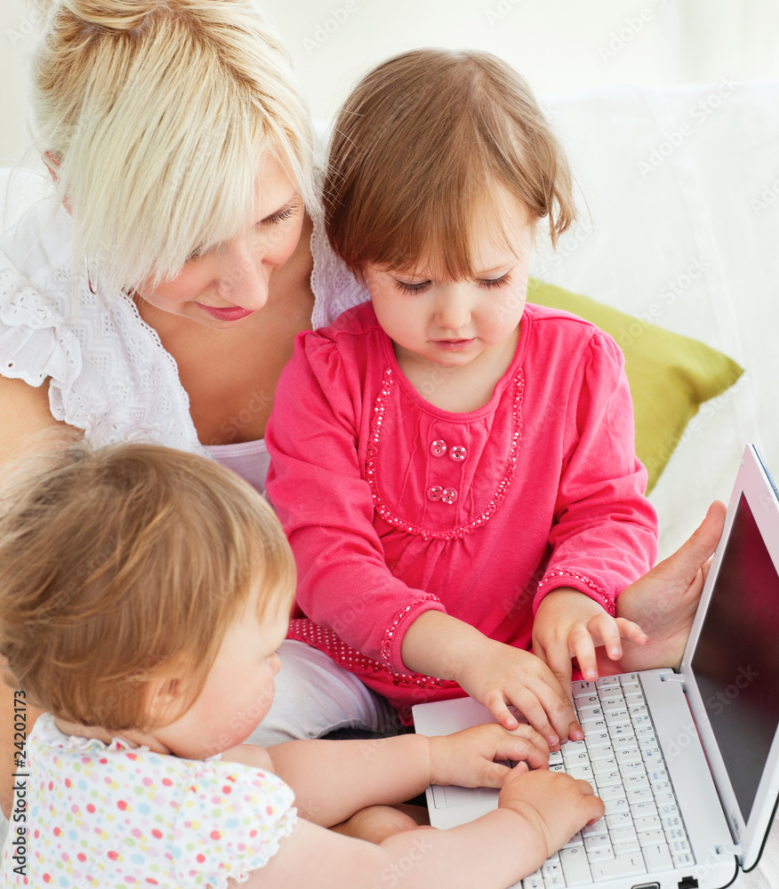 Cheerful family having fun with a laptop in the living-room Cheerful family having fun with a laptop in the living-room