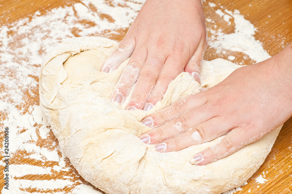 female hands kneading dough on table female hands kneading dough on table