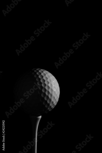 golf ball on a tee, in dramatic black and white