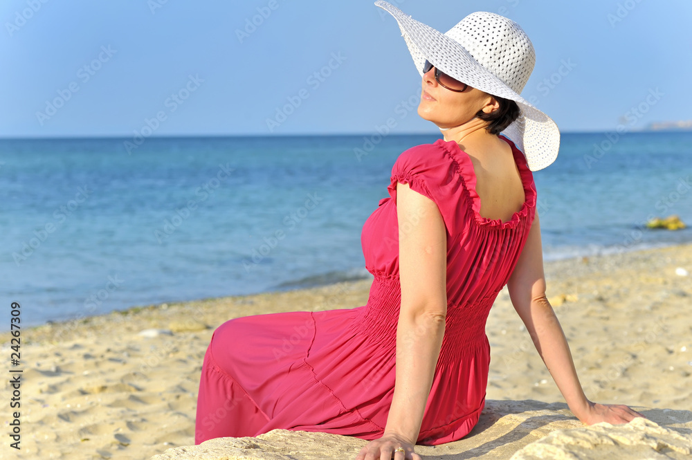 Portrait of beautiful female  in red dress on beach