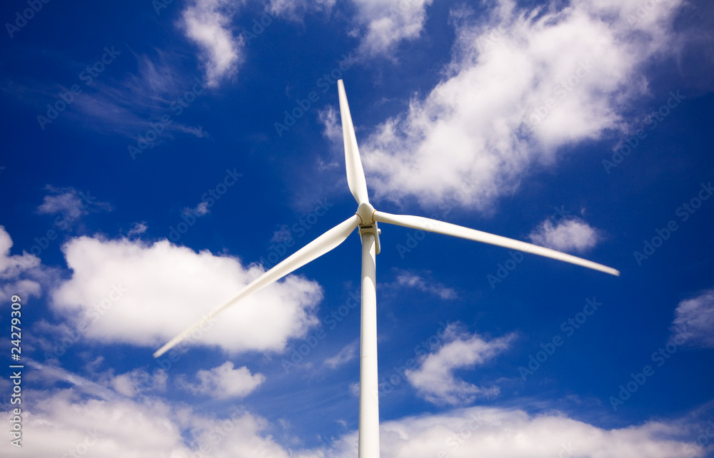 Windmill against a blue sky and clouds, alternative energy sourc Windmill against a blue sky and clouds, alternative energy sourc