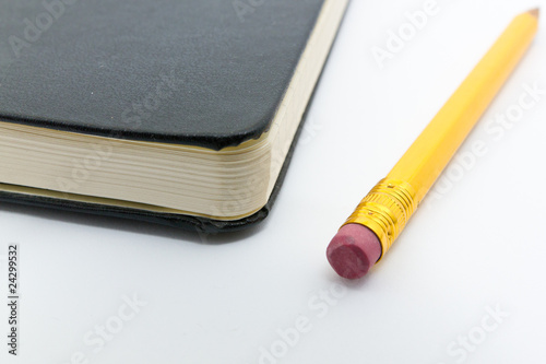 Bleistift mit Radiergummi neben Notizbuch