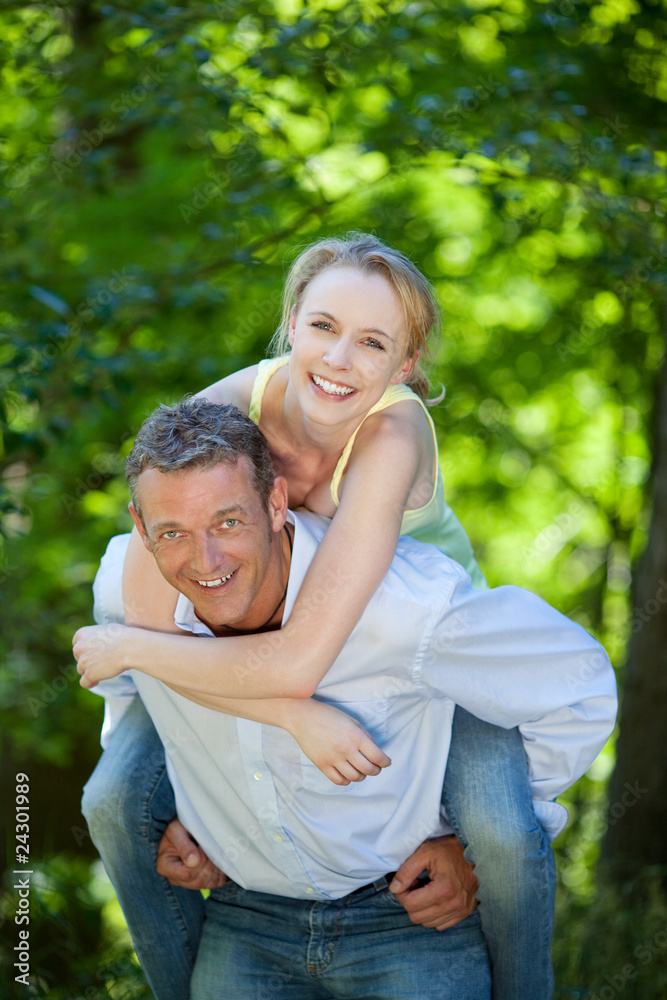 Fototapeta premium mann trägt frau im huckepack