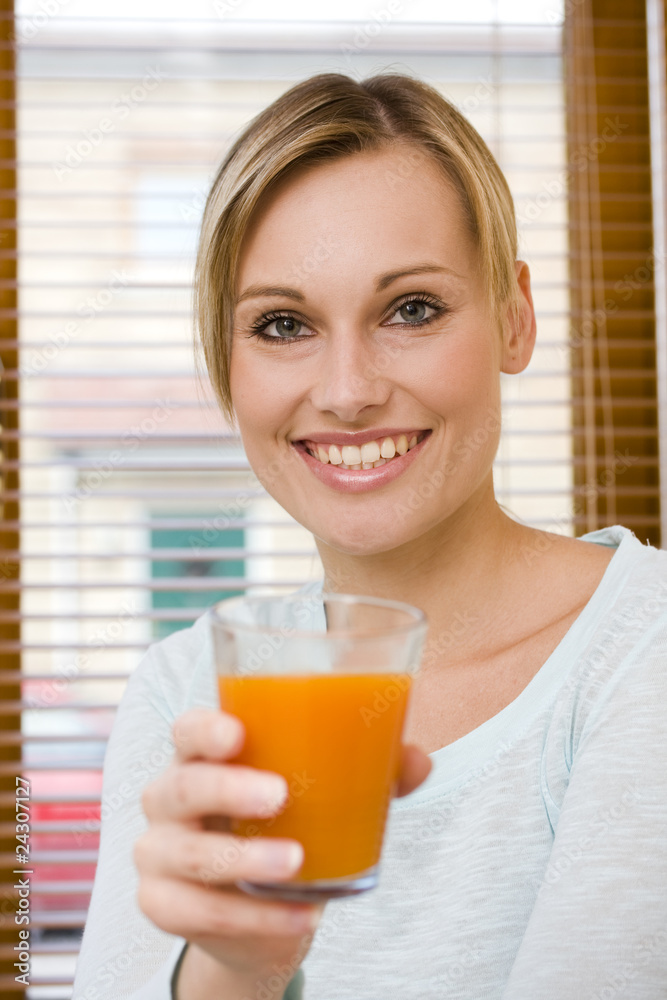 Beautiful young woman holding glassful of orange juice Beautiful young woman holding glassful of orange juice