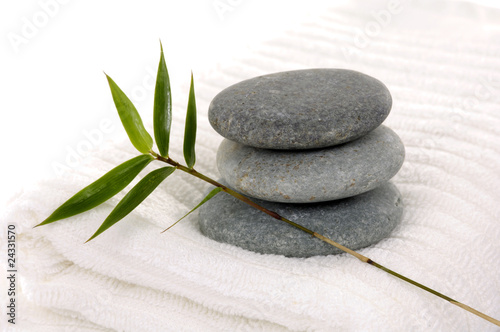 Zen stones with bamboo leaf on towel