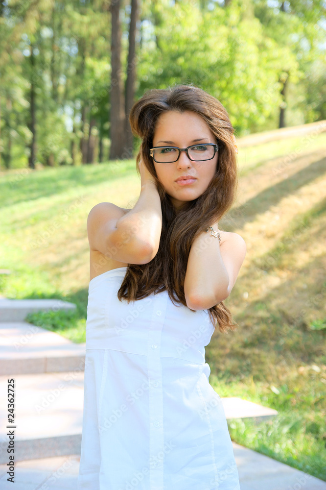 Young woman with glasses in white dress outdoor