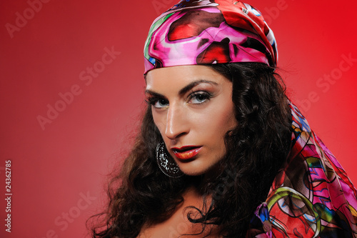 Obraz na plátně Beautiful gipsy woman with bright make-up. red background