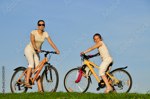 Mother and her dauhgter riding on a bicycles