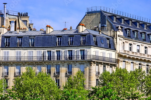 Fotografija Immeubles de pierre blanche aux toits gris avec arbres.