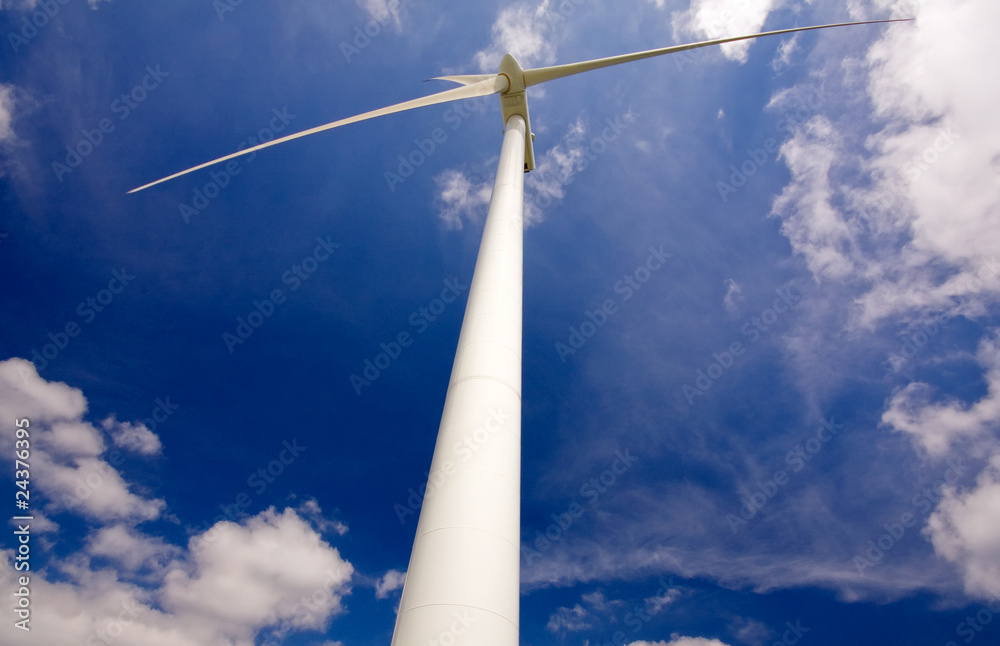Windmill against a blue sky and clouds, alternative energy sourc Windmill against a blue sky and clouds, alternative energy sourc