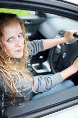 Pretty young woman driving her new car © lightpoet