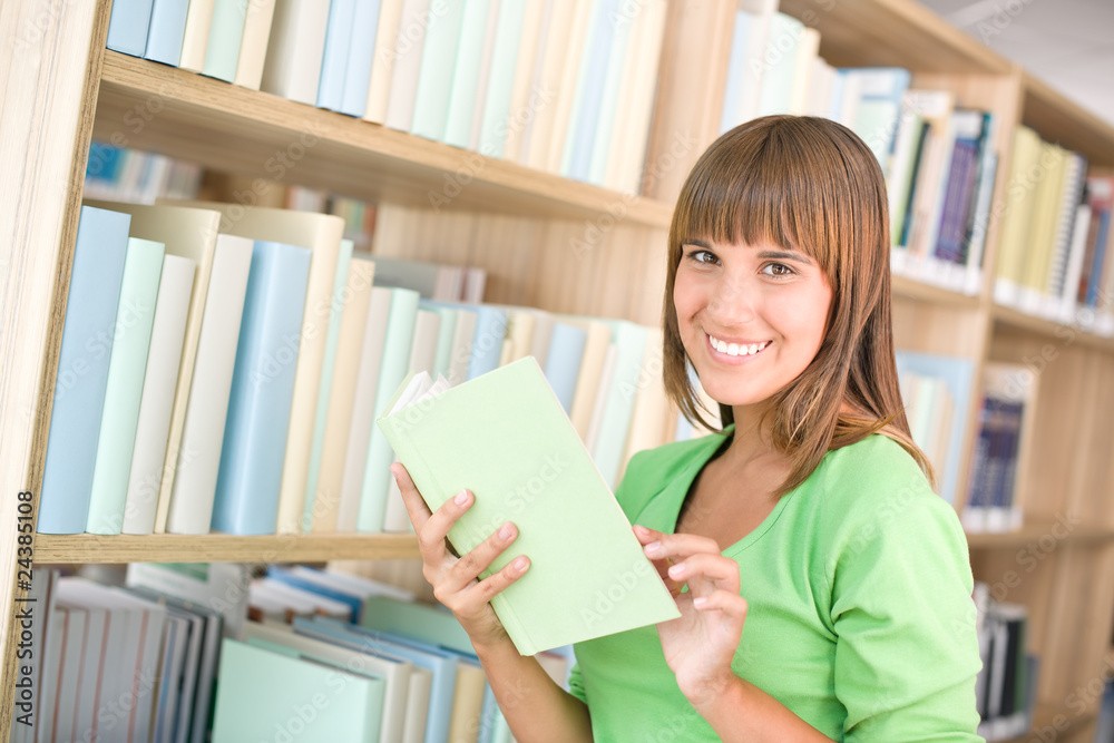 Student in library - cheerful woman choose book Student in library - cheerful woman choose book
