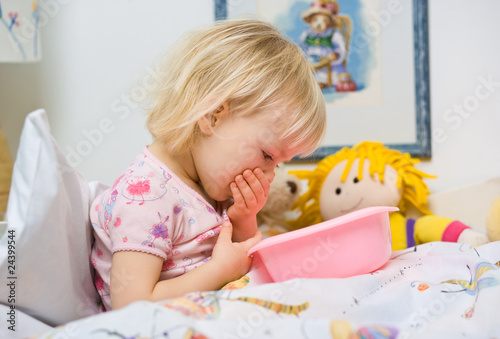 little sick girl in bed with bowl