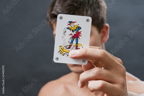 Obraz na plátne Joker in a hand with man