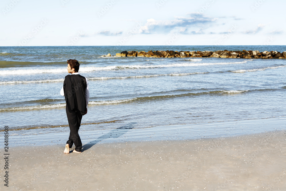 Young businessman in contemplation looking at ocean Young businessman in contemplation looking at ocean