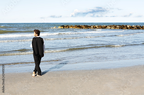 Young businessman in contemplation looking at ocean