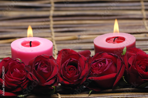 Red rose and candles isolated on bamboo mat