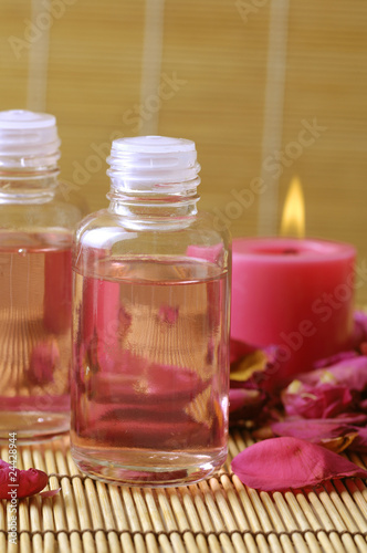 Aromatic oil and candle on bamboo mat