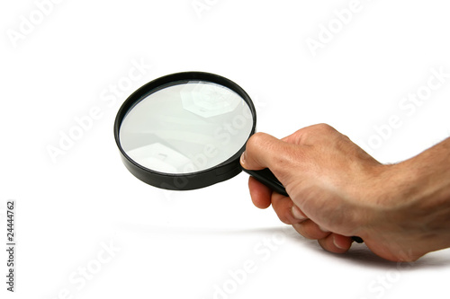 Hand holding a magnifier on white background