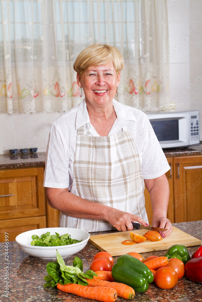 senior woman making a healthy salad in kitchen senior woman making a healthy salad in kitchen