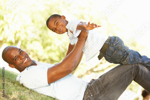 Fototapeta Naklejka Na Ścianę i Meble -  Portrait of Happy Father and Son In Park