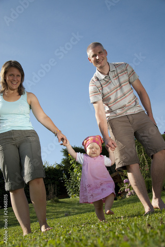 junge familie spaziert im garten ihres eigenheims © Arthur Braunstein