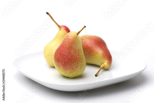 Three pears on a white plate, white background