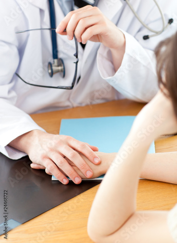 Attractive doctor holding hand of patient